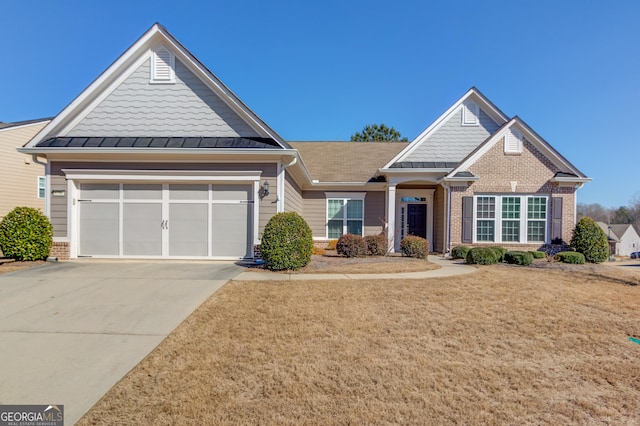 craftsman-style house with brick siding, concrete driveway, a standing seam roof, metal roof, and a garage