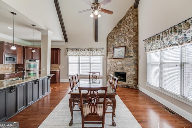 5016 Deer Creek Ct, Flowery Branch, GA 30542 - dining room with ceiling fan, healthy amount of natural light, dark wood-style flooring, a stone fireplace, and high vaulted ceiling