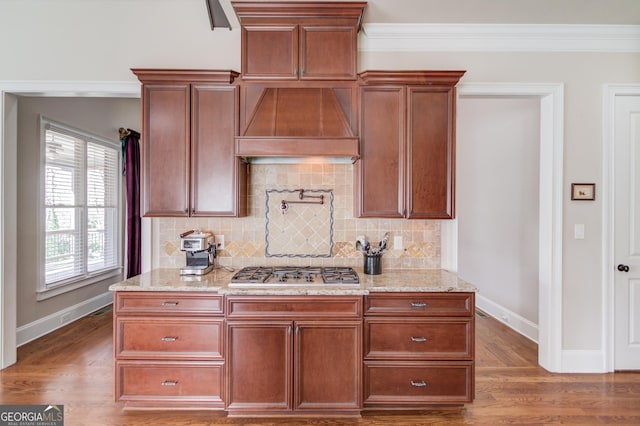 5016 Deer Creek Ct, Flowery Branch, GA 30542 - kitchen with premium range hood, stainless steel gas stovetop, backsplash, light stone counters, and wood finished floors
