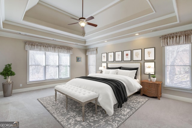 bedroom featuring baseboards, a ceiling fan, ornamental molding, carpet, and a tray ceiling