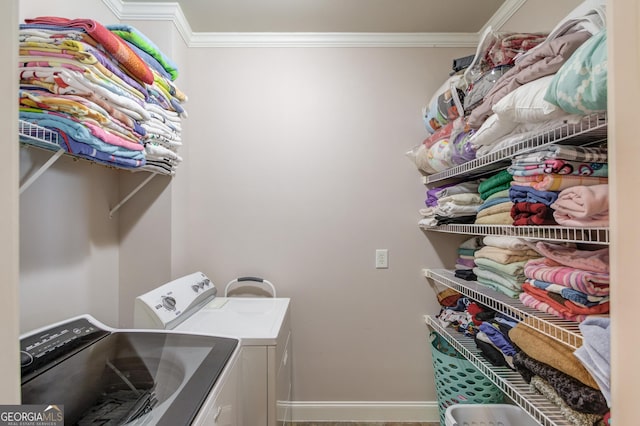 laundry room with ornamental molding, washer and dryer, laundry area, and baseboards