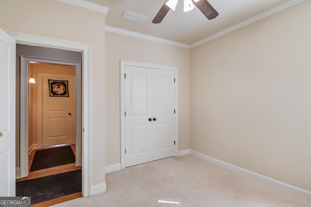 unfurnished bedroom featuring ornamental molding, carpet, a closet, and baseboards