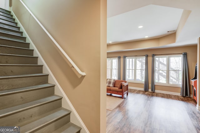 staircase featuring plenty of natural light, wood finished floors, visible vents, and recessed lighting