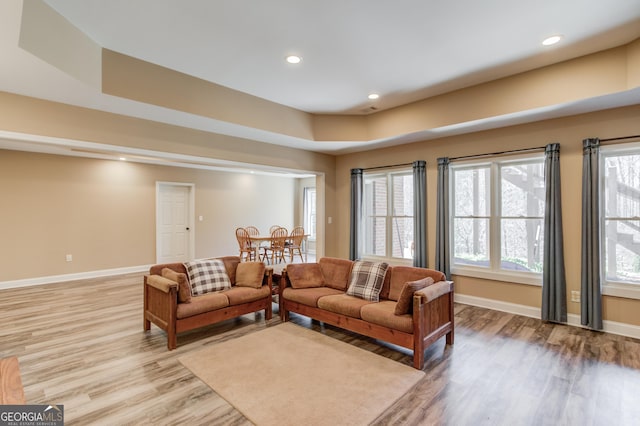 living area with light wood-type flooring, plenty of natural light, baseboards, and recessed lighting