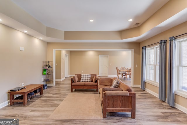 living area with light wood finished floors, baseboards, and visible vents