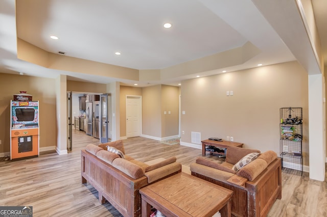 living room featuring baseboards, recessed lighting, visible vents, and light wood-style floors