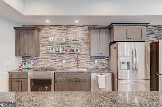 kitchen featuring tasteful backsplash, stone countertops, stainless steel appliances, a sink, and recessed lighting