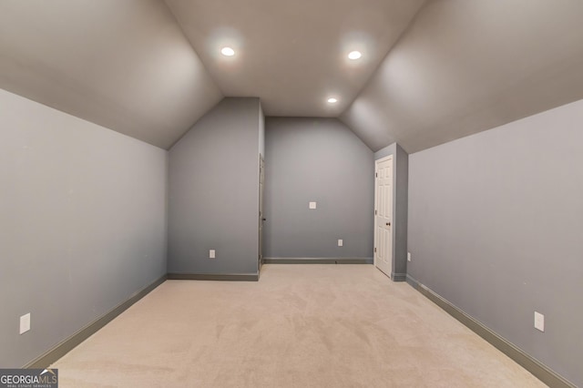 additional living space with lofted ceiling, light colored carpet, baseboards, and recessed lighting