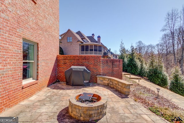 view of patio / terrace with an outdoor fire pit, fence, and grilling area