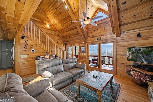 living room featuring light wood finished floors, wooden ceiling, and wooden walls