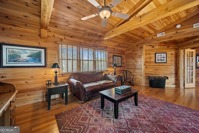 living room featuring lofted ceiling with beams, wood finished floors, wood ceiling, and wooden walls