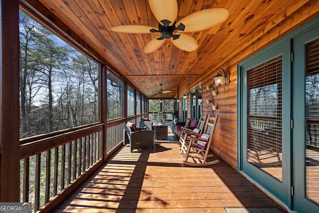 unfurnished sunroom with wood ceiling and a ceiling fan