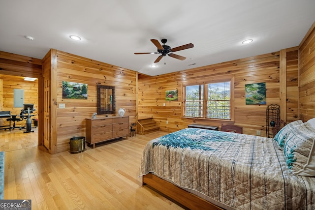 bedroom featuring recessed lighting, electric panel, wood walls, and wood finished floors