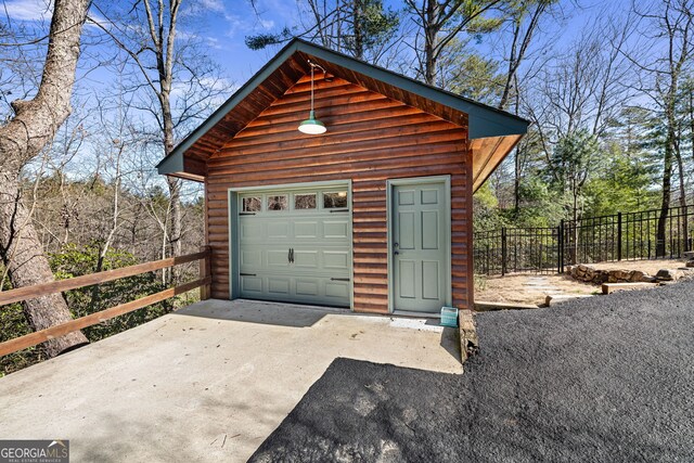 detached garage with fence and driveway