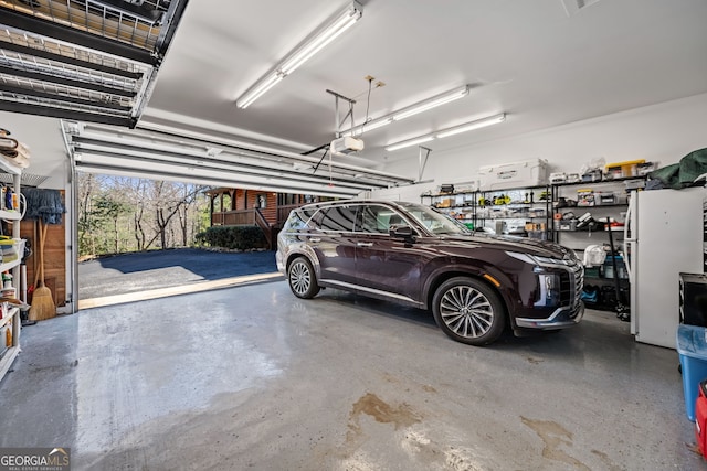 garage with freestanding refrigerator and a garage door opener