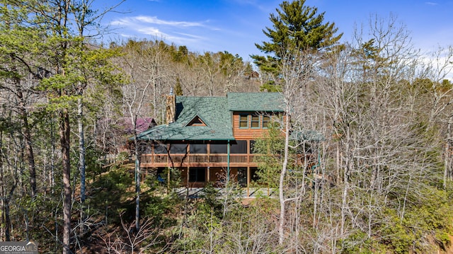 back of property featuring a sunroom and a shingled roof