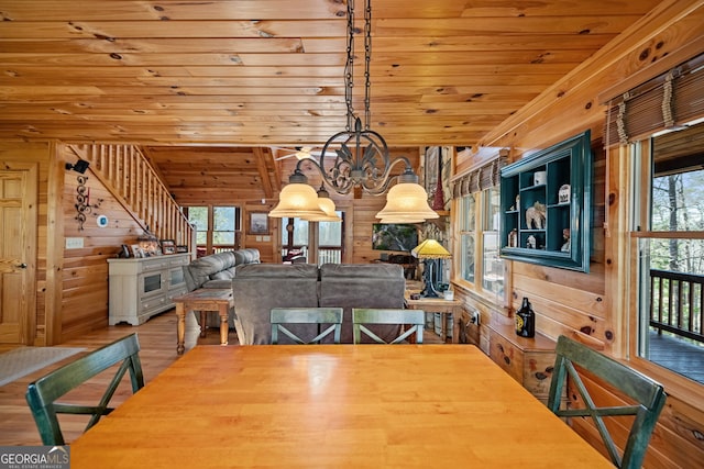 unfurnished dining area with stairway, wood ceiling, wooden walls, and wood finished floors