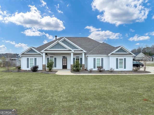 view of front of home featuring a shingled roof, board and batten siding, and a front yard