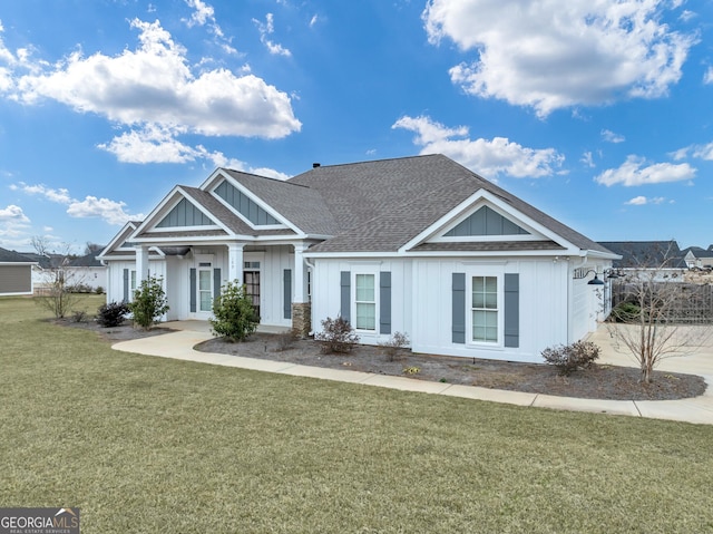 craftsman house featuring a front lawn, board and batten siding, and roof with shingles