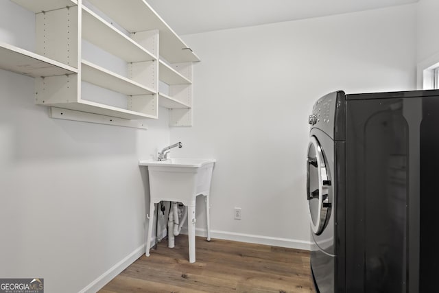 laundry room with washer / dryer, baseboards, laundry area, and wood finished floors