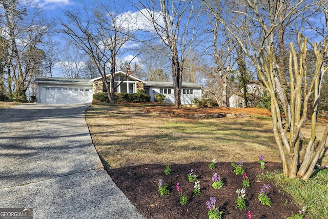 view of front facade featuring driveway, an attached garage, and a front yard