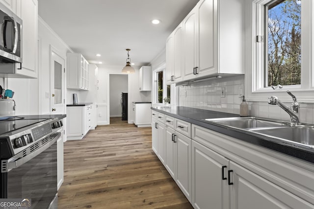 kitchen with stainless steel appliances, a healthy amount of sunlight, a sink, and white cabinets