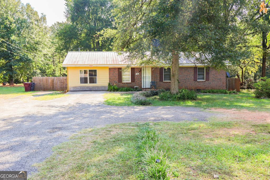 9836 Ga Highway 83 S, Monticello, GA 31064 - single story home with brick siding, gravel driveway, fence, and a front yard