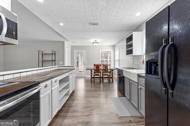 kitchen with wood finished floors, visible vents, open shelves, stainless steel appliances, and wine cooler