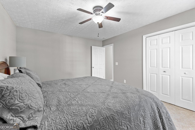 bedroom with a closet, a textured ceiling, ceiling fan, and carpet