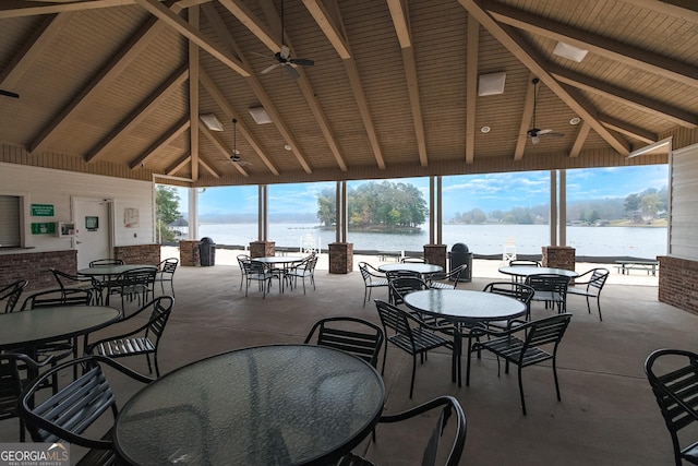 view of patio / terrace with a gazebo, outdoor dining area, a ceiling fan, and a water view