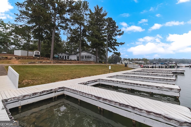 view of dock with a lawn and a water view