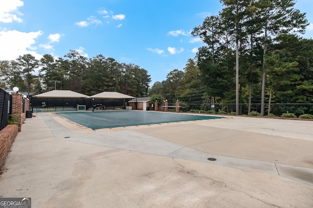 community pool with a patio and fence