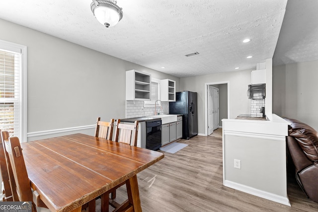 dining space featuring baseboards, visible vents, recessed lighting, a textured ceiling, and light wood-type flooring