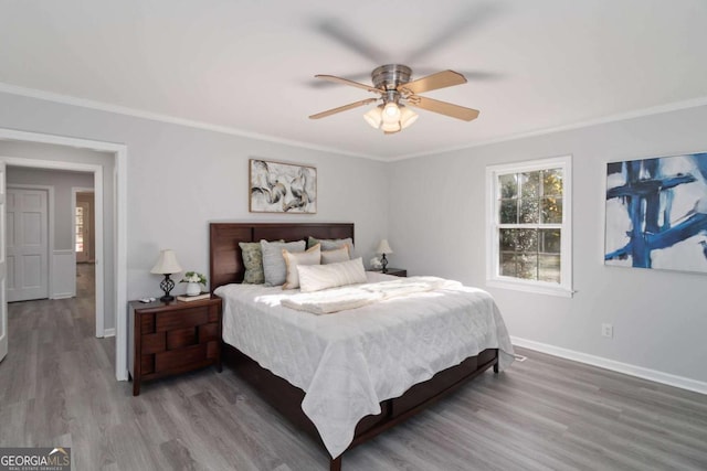 bedroom with ornamental molding, wood finished floors, a ceiling fan, and baseboards