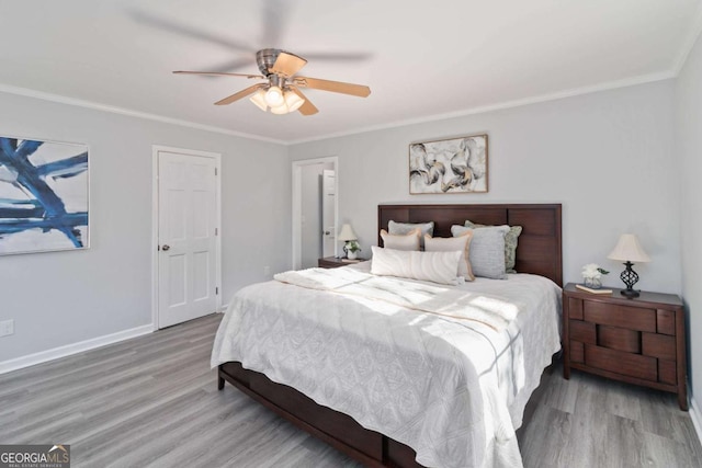 bedroom with baseboards, ornamental molding, and wood finished floors