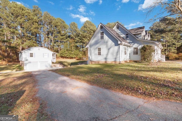 view of property exterior featuring a detached garage and a lawn