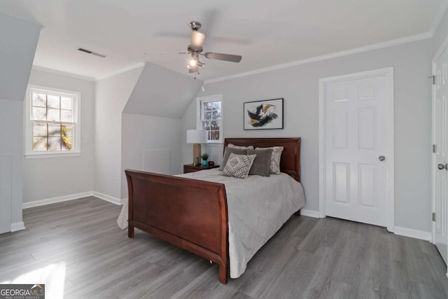 bedroom featuring ornamental molding, wood finished floors, and visible vents