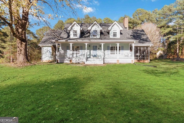 view of front facade featuring a sunroom, a chimney, a front lawn, and covered porch