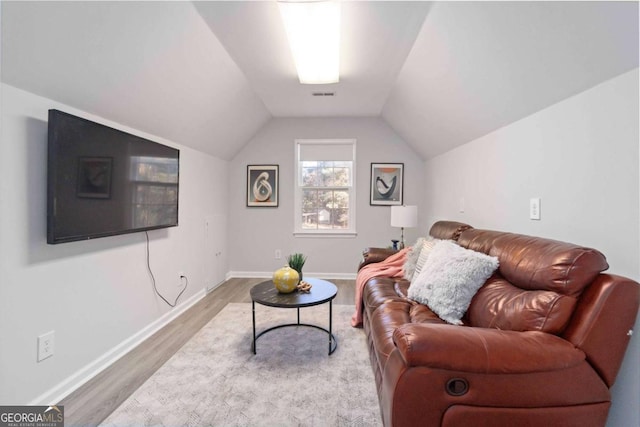 living area with baseboards, visible vents, vaulted ceiling, and wood finished floors