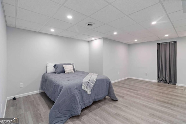 bedroom featuring light wood-type flooring, visible vents, and baseboards