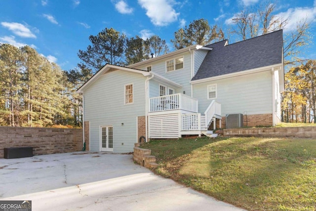 back of house featuring roof with shingles, cooling unit, a lawn, and french doors