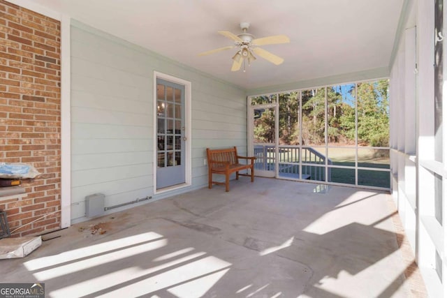 unfurnished sunroom with ceiling fan