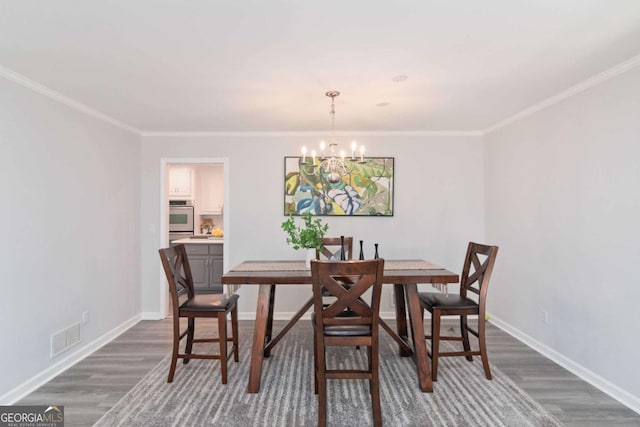 dining space featuring dark wood-style floors, a chandelier, visible vents, and baseboards