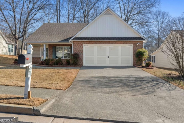 view of front of home featuring brick siding, roof with shingles, covered porch, a garage, and driveway