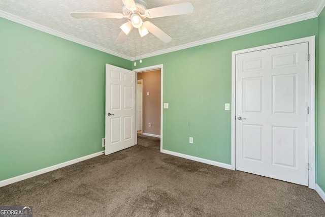 unfurnished bedroom featuring a textured ceiling, carpet floors, ornamental molding, and baseboards