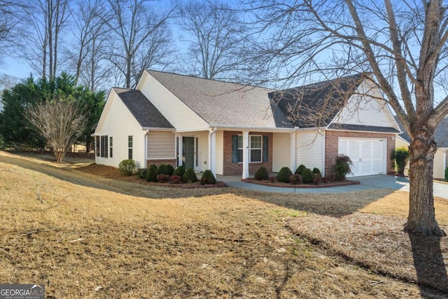 ranch-style home with a garage, brick siding, driveway, roof with shingles, and a front lawn