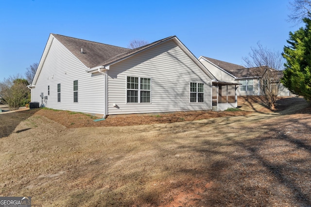 back of house with a lawn and a sunroom