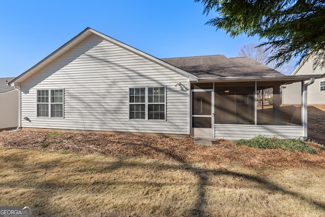 view of side of property featuring a sunroom and a yard