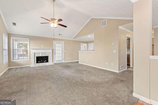 unfurnished living room with crown molding, a high end fireplace, visible vents, and light colored carpet