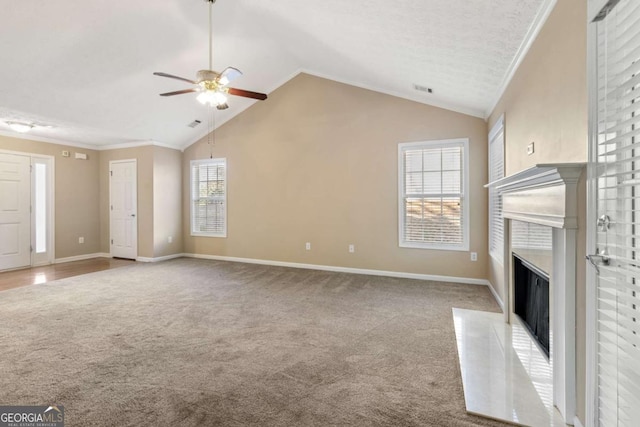 unfurnished living room with ornamental molding, vaulted ceiling, carpet flooring, and a fireplace